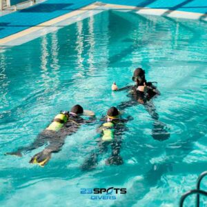 Anfänger übt mit Ausrüstung im Schwimmbecken.